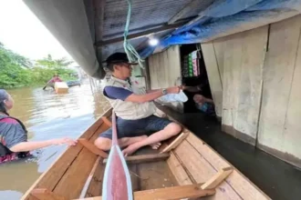 Kalaksa BPBD Murung Raya, Fitrianul Fahriman saat menyalurkan bantuan makanan kepada warga terdampak banjir di Desa Bahitom, Kamis (10/10).