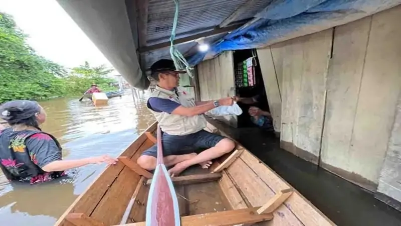 Kalaksa BPBD Murung Raya, Fitrianul Fahriman saat menyalurkan bantuan makanan kepada warga terdampak banjir di Desa Bahitom, Kamis (10/10).