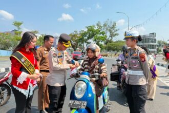 Kepolisian Daerah (Polda) Kalimantan Tengah membagikan bendera Merah Putih kepada para pengendara di kawasan Bundaran Besar Talawang, Kota Palangka Raya, Senin (10/8/2026).
