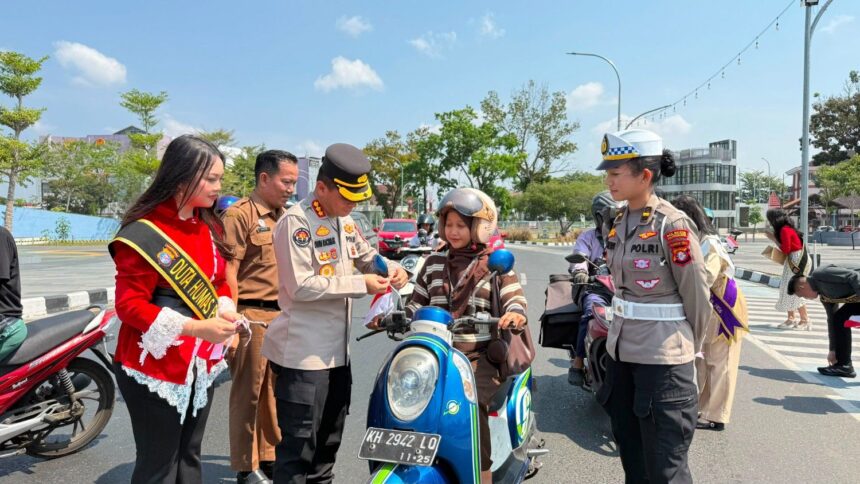 Kepolisian Daerah (Polda) Kalimantan Tengah membagikan bendera Merah Putih kepada para pengendara di kawasan Bundaran Besar Talawang, Kota Palangka Raya, Senin (10/8/2026).